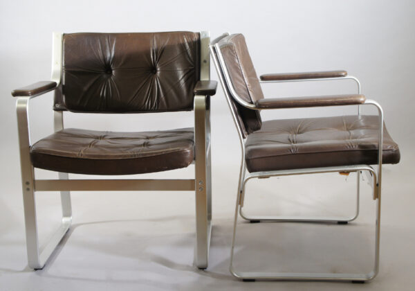 Karl-Erik Ekselius for C-O Carlsson, Sweden. ¨Mondo¨. A pair of arm chairs in aluminium and seats in brown leather. 69x63, height 80 cm. Karmstolar i skinn. Wigerdals Värld