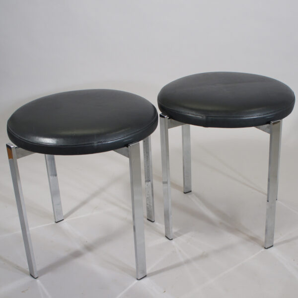 A pair of stools in crome steel and seats in leather. Maker unknown. Height 47, diam 45 cm.