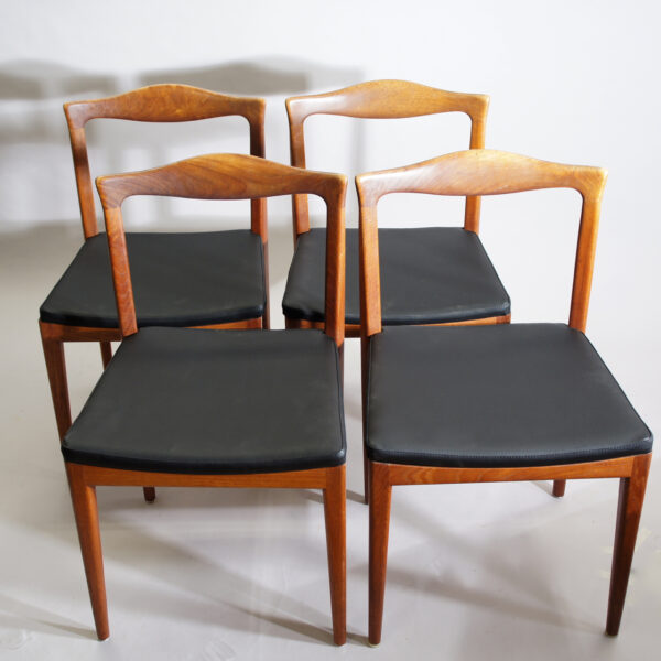 Four side chairs in teak with seat cover in leather imitation.