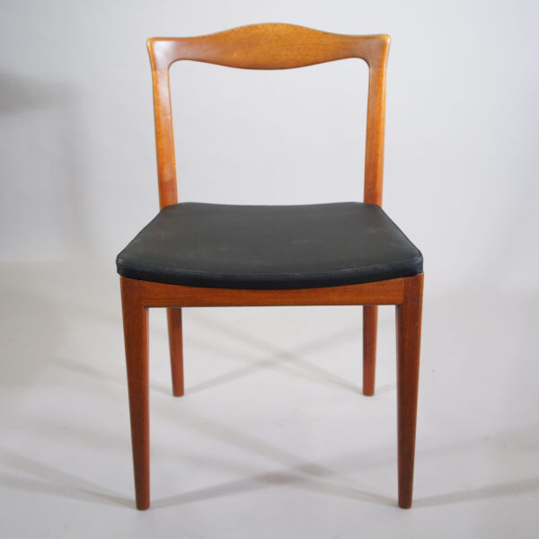 Four side chairs in teak with seat cover in leather imitation.
