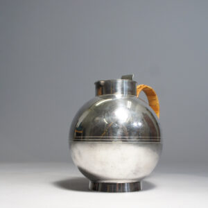 Sylvia Stave for C.G. Hallberg, Sweden. Jug in silver plated alpacka with cane covered handle. Designed 1933. Height 17 cm. Kanna i silver. Wigerdals.com