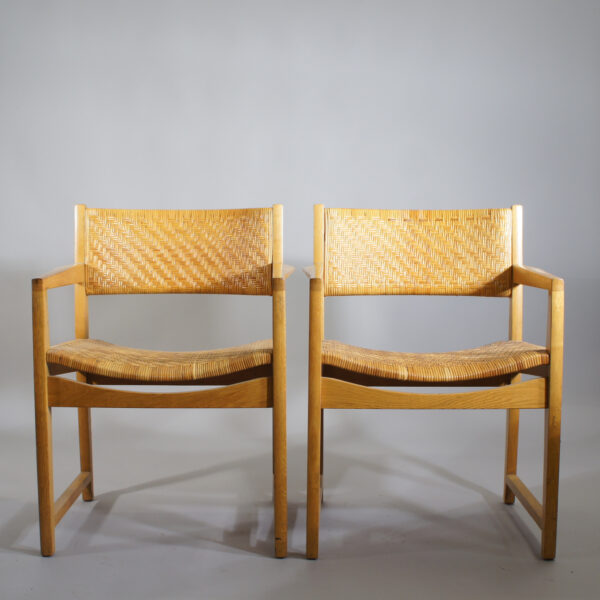 A pair of arm chairs in oak and rattan. Karmstol rotting ek Wigerdals