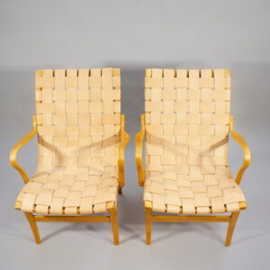 Bruno Mathsson for Karl Mathsson. "Eva". A pair of arm chairs in beech with new webbing in leather. Karmstolar med sadelgjord i läder Wigerdal