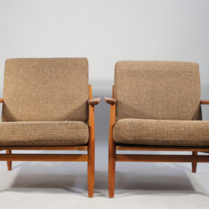 A pair of easy chairs in teak with wool fabric.