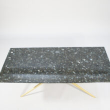 A 1950's coffee table in black granite and brass.