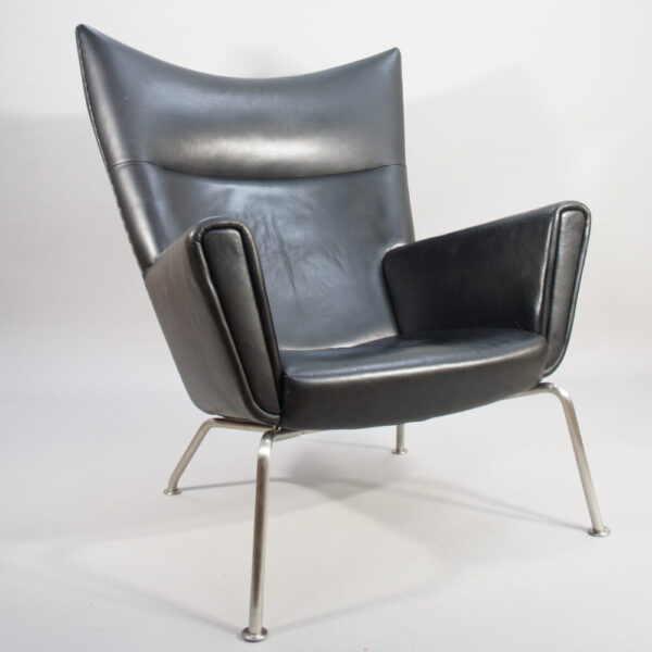 Hans J. Wegner for Carl Hansen, Denmark. "Wing chair" CH 445. Chair in black leather and legs in brushed steel.