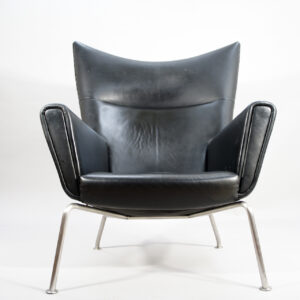 Hans J. Wegner for Carl Hansen, Denmark. "Wing chair" CH 445. Chair in black leather and legs in brushed steel.