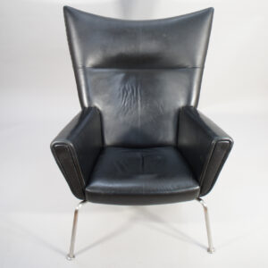 Hans J. Wegner for Carl Hansen, Denmark. "Wing chair" CH 445. Chair in black leather and legs in brushed steel.