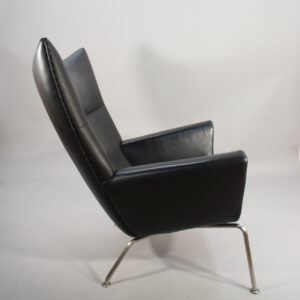 Hans J. Wegner for Carl Hansen, Denmark. "Wing chair" CH 445. Chair in black leather and legs in brushed steel.